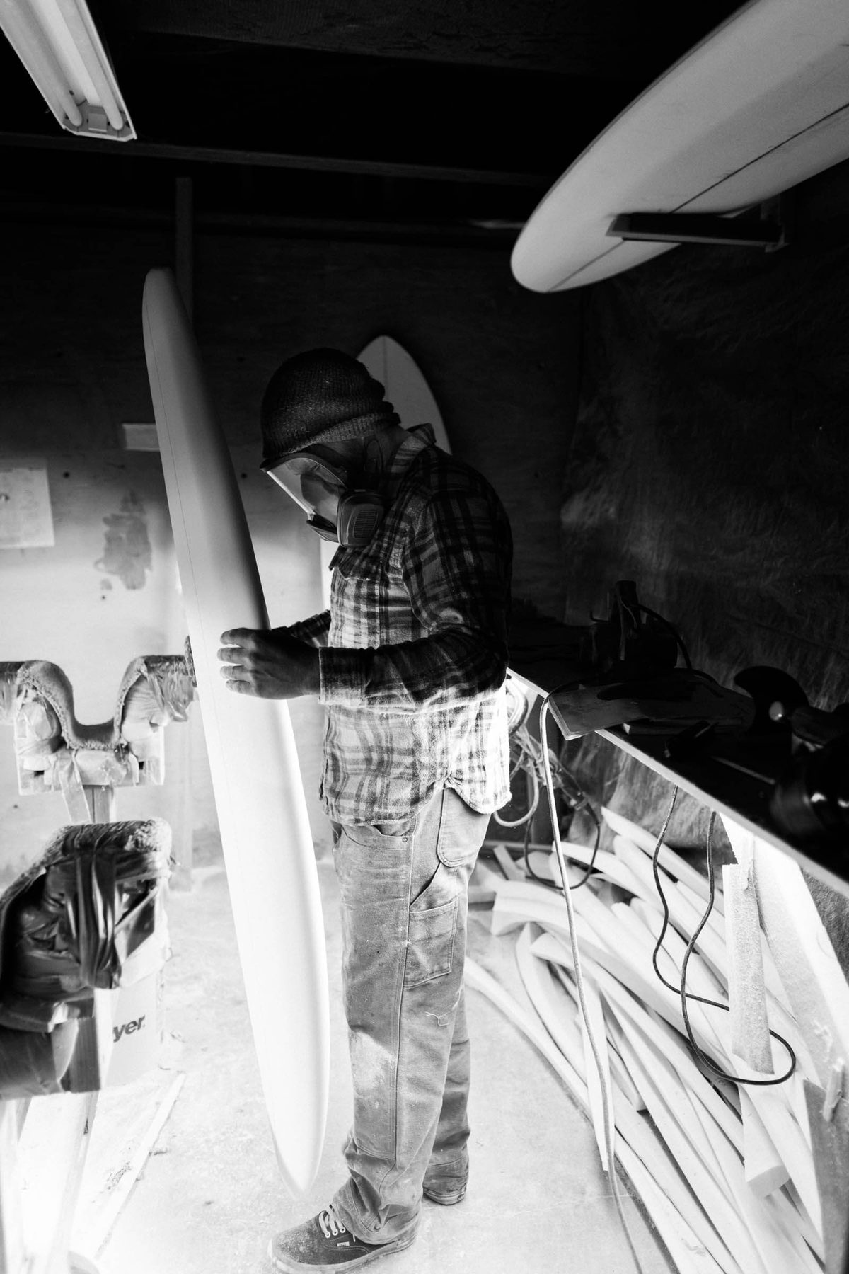 The shaping bay, walls draped, a board on the stand