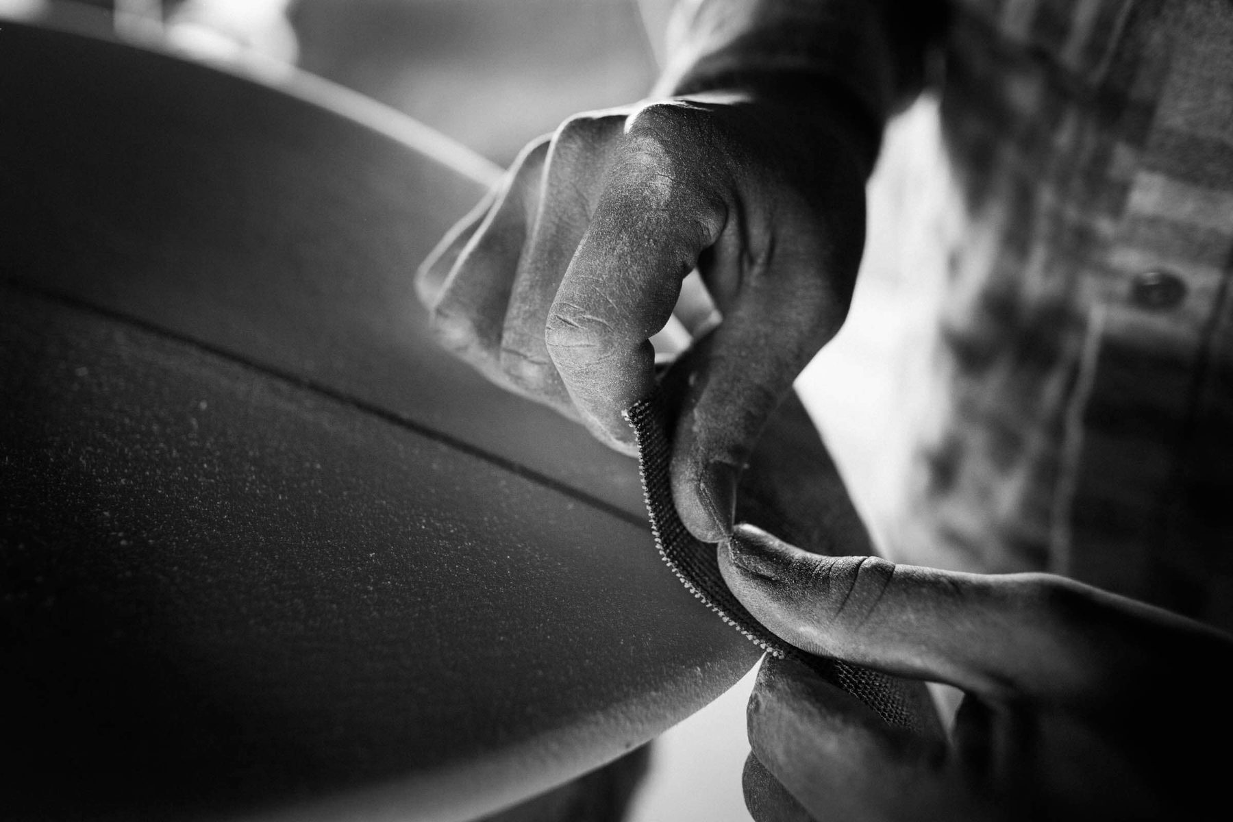 Hands working the rail of a board